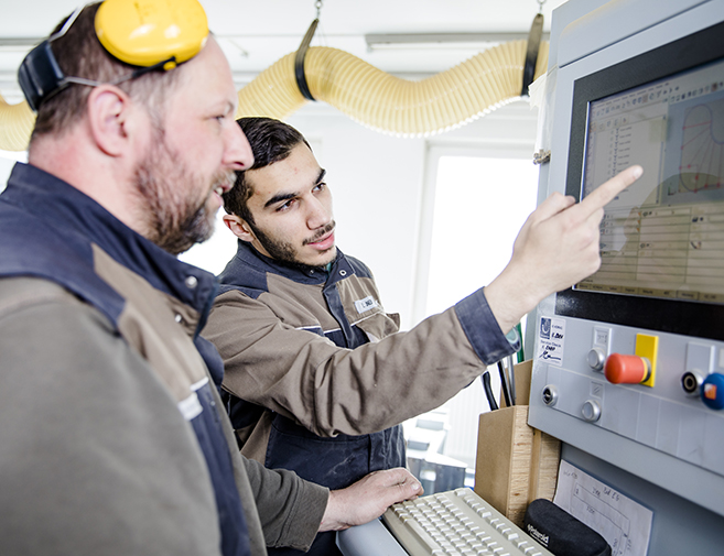 Tischler bei der CNC-Programmierung in der Werkstatt der Tischlerei Siebert in Melle Zwei Tischler besprechen eine CNC-Maschinensteuerung am Bildschirm – präzise Planung und Fertigung in der Werkstatt